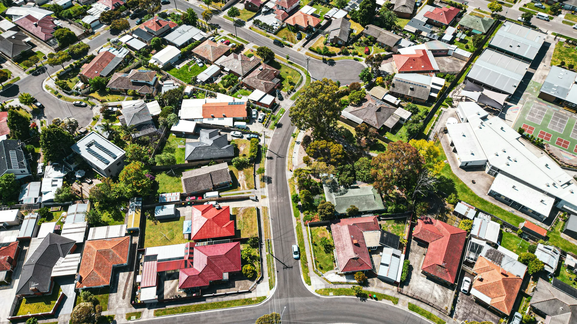 Aerial view of a suburban neighbourhood in Melbourne with houses, streets, and trees.